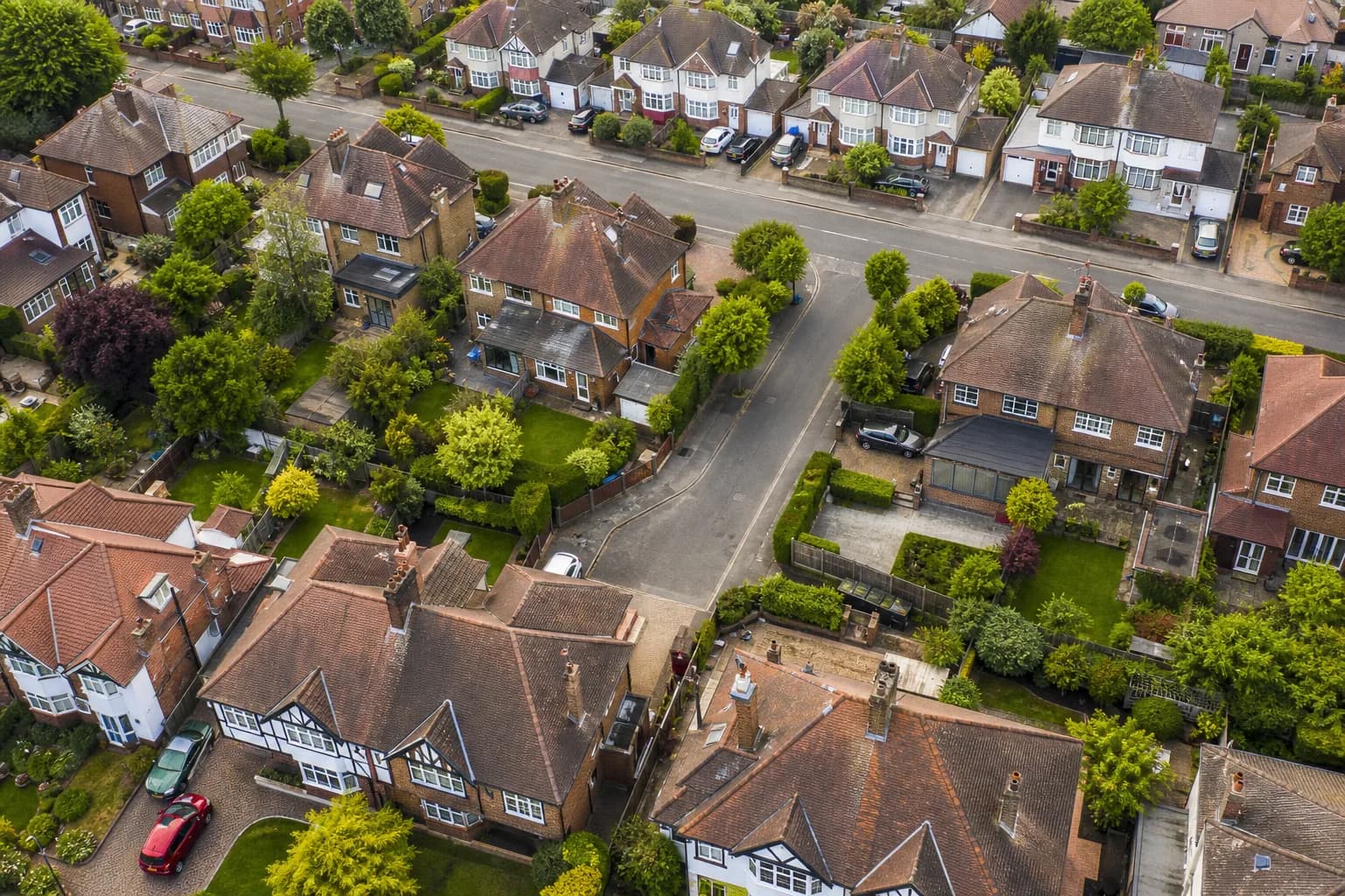 Aerial view of UK suburban rooftops and driveways