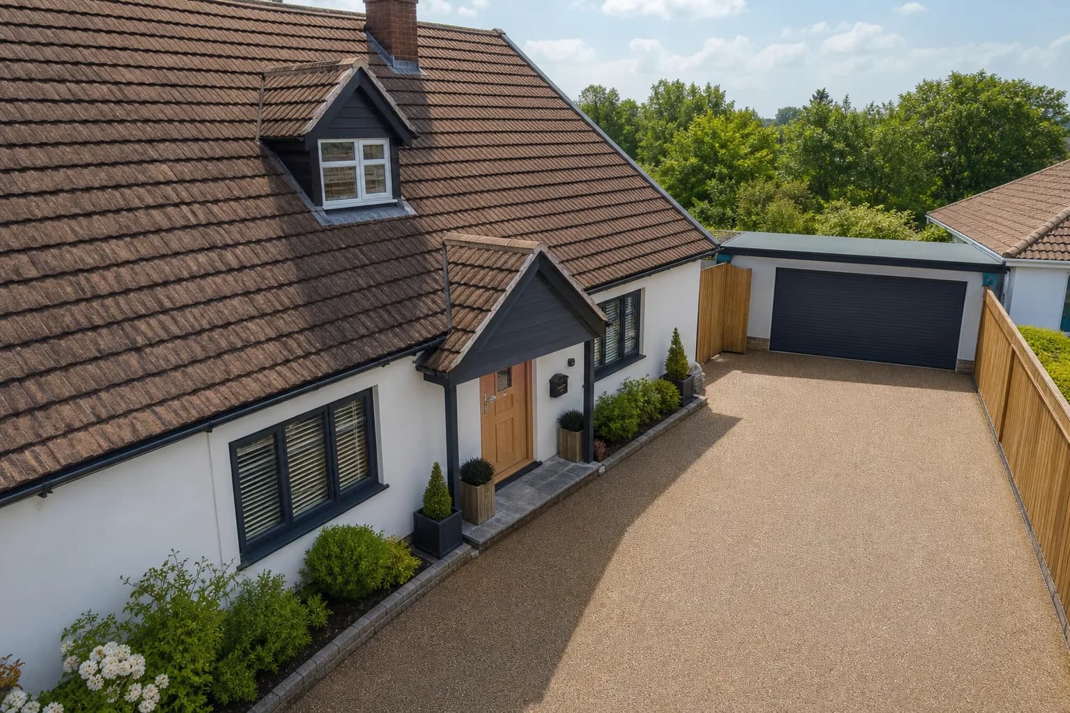 A tiled house roof beside a smart resin driveway