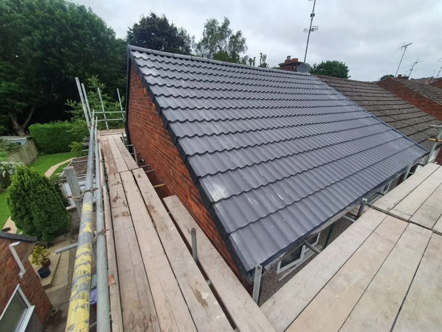 Newly re-roofed detached house with scaffolding, completed by Liberty Contractors